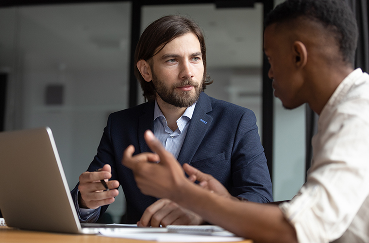 Focused businessman listening to young employee.